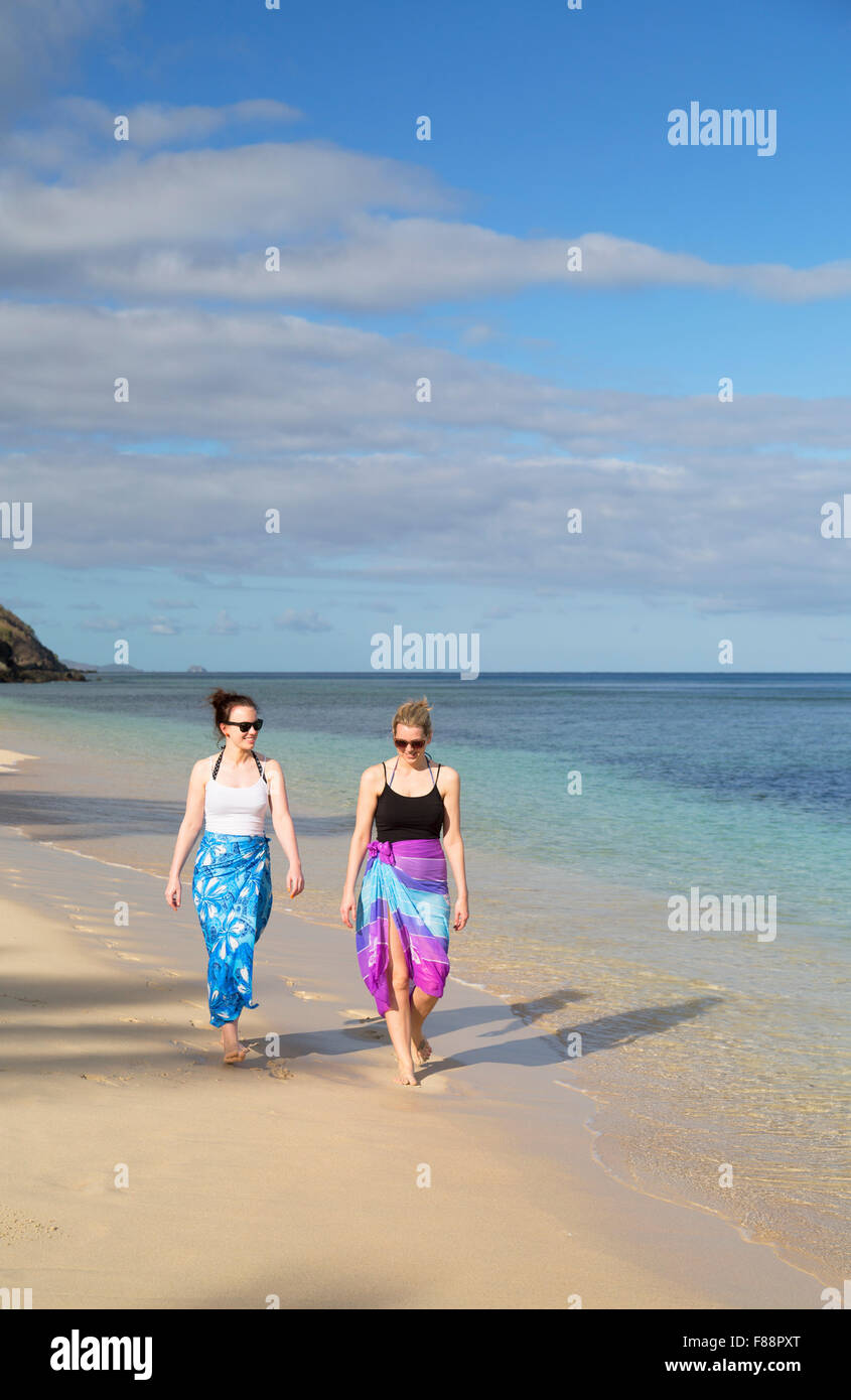 Le donne a piedi sulla spiaggia a Octopus Resort, Waya Island, Yasawa Islands, Isole Figi (MR) Foto Stock