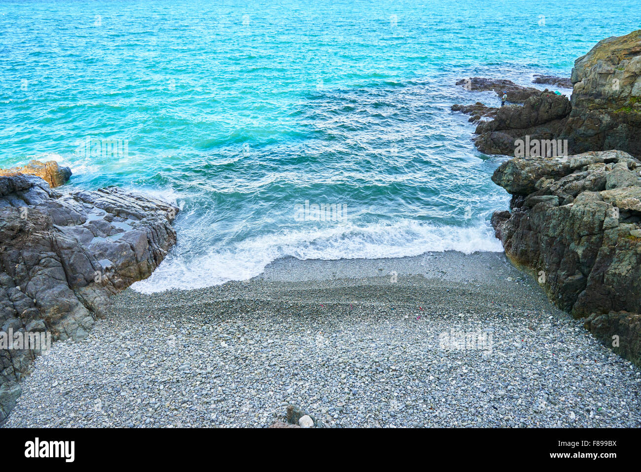 Il mare blu e stretta spiaggia di ciottoli di Busan, Corea. Foto Stock