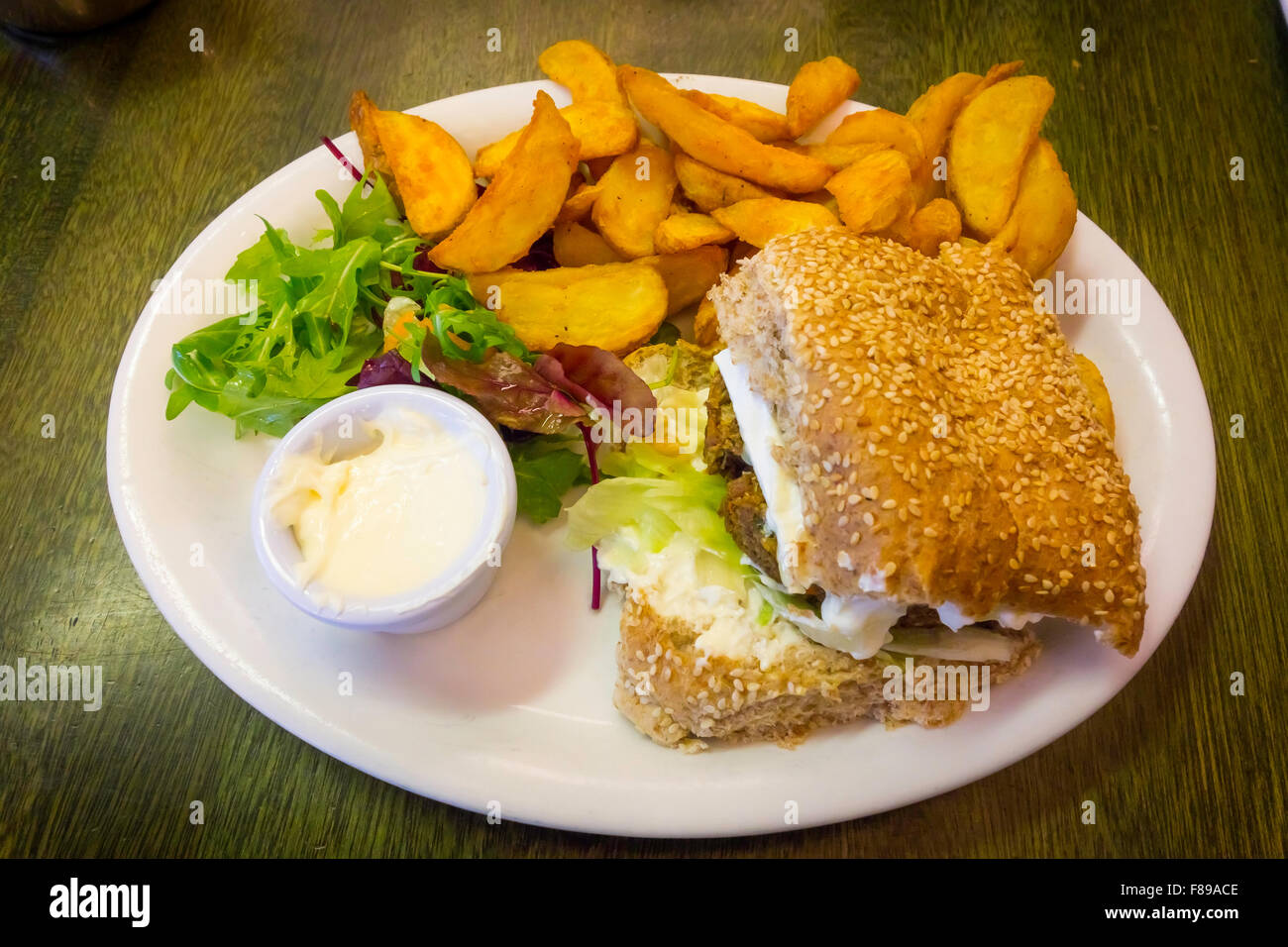 Café vegetariano pranzo un hamburger vegetali francese con Formaggio Brie insalata maionese e patatine fritte Foto Stock