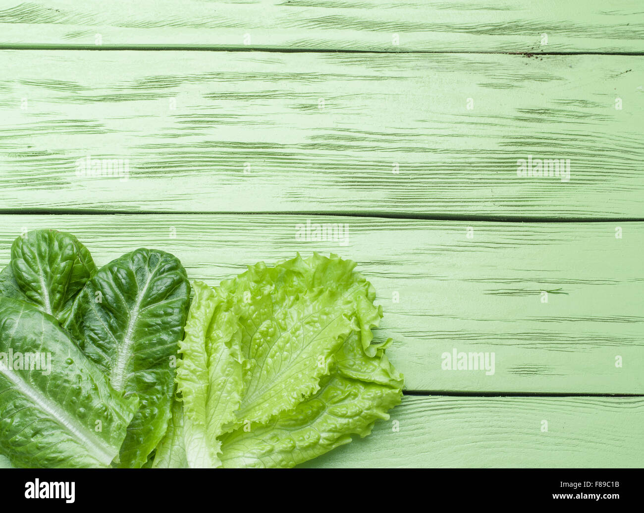 Su insalata verde sullo sfondo di legno. Foto Stock
