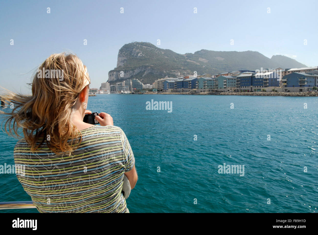 Gibilterra dal mare con la roccia in background e il nuovo sviluppo nella terra di mezzo. Turisti in primo piano. Foto Stock
