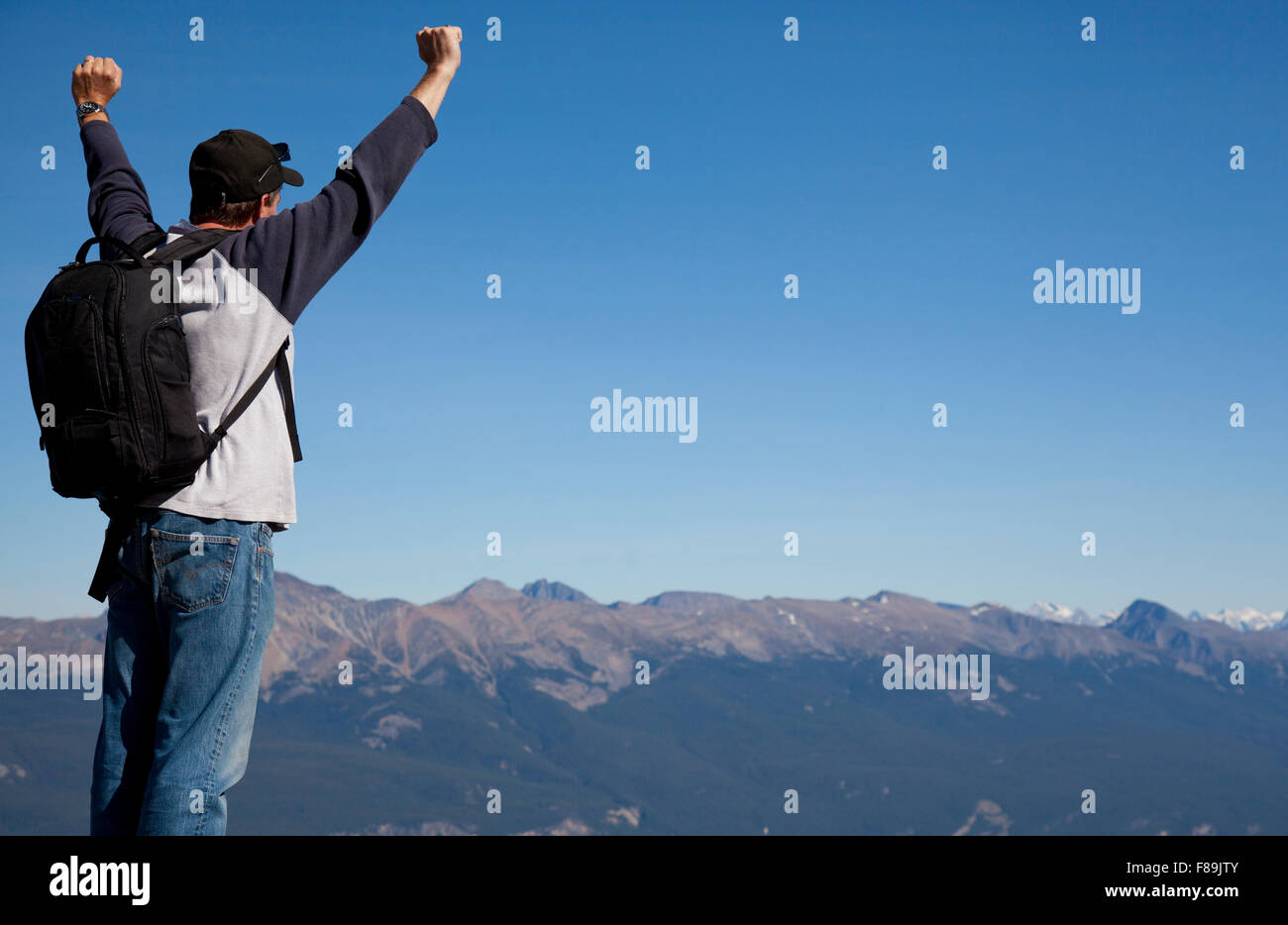 Felice e vittorioso escursionista celebrando sul vertice di montagna Foto Stock