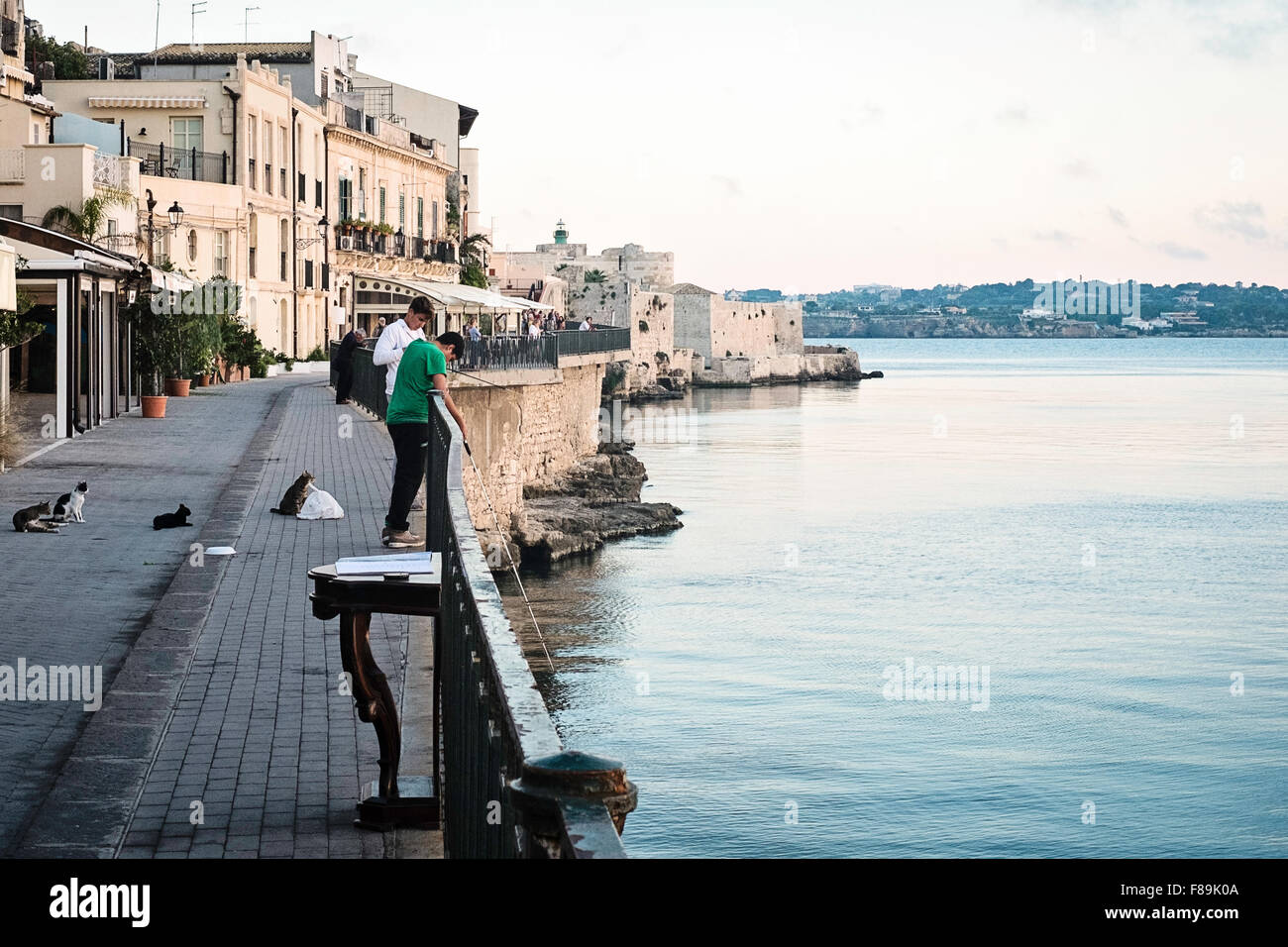 Pesca notturna dal lungomare di Porto Grande, Ortigia, Sicilia, Italia Foto Stock