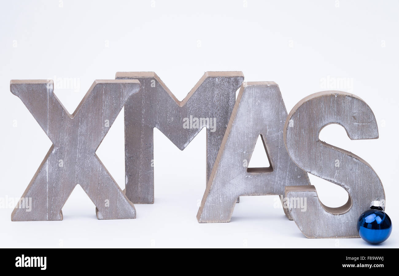 Lettere maiuscole formante la parola x-mas con blue palla di Natale su bianco Foto Stock