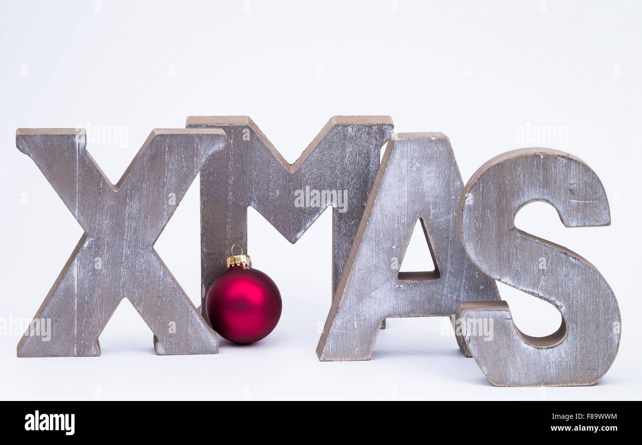 Lettere maiuscole formante la parola x-mas con la rossa palla di Natale su bianco Foto Stock