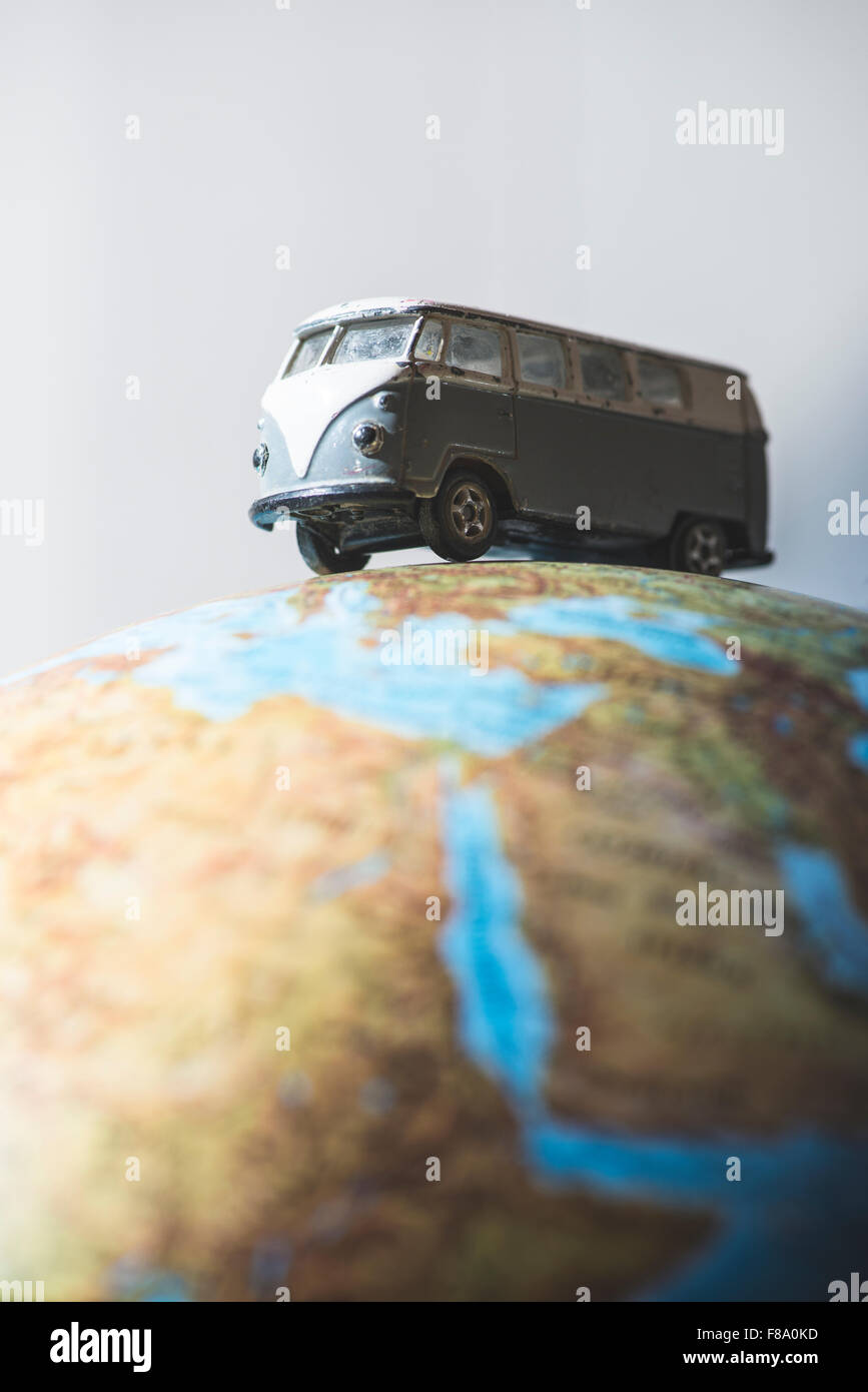 Vintage bus VW sul globo terrestre. Concetto in miniatura Foto Stock