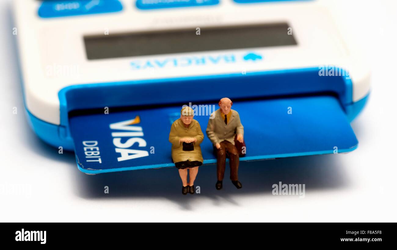 Due pensionato in miniatura figure seduto su una Visa Debit Card Foto Stock