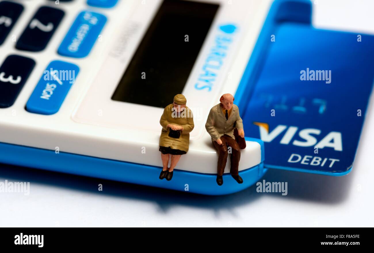 Due pensionato in miniatura figure seduto su un perno sentry macchina con una Visa Debit Card all'interno Foto Stock