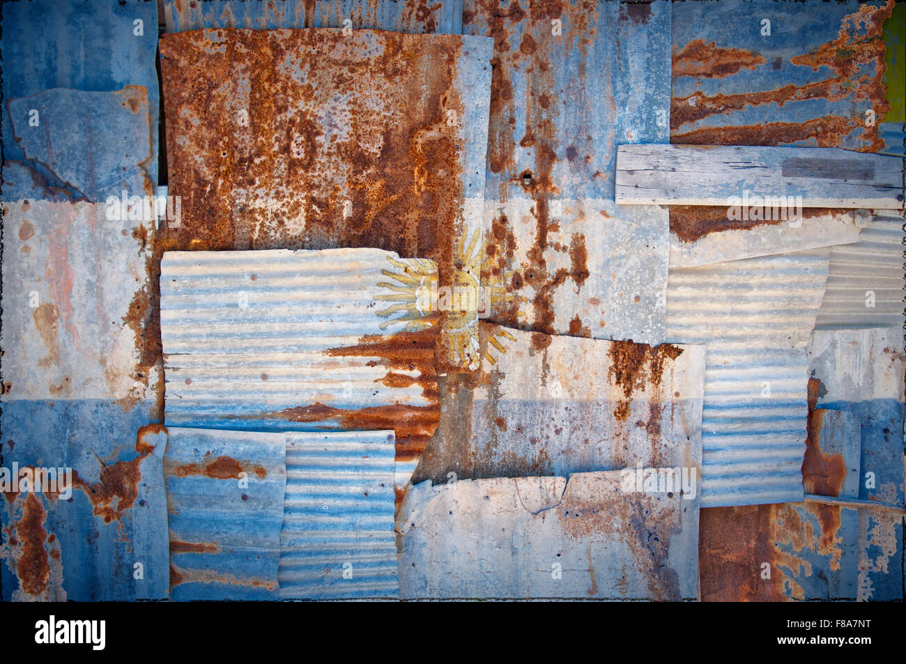 Un abstract immagine di sfondo della bandiera dell'Argentina dipinta su di rusty ferro corrugato fogli sovrapposti per formare una parete Foto Stock