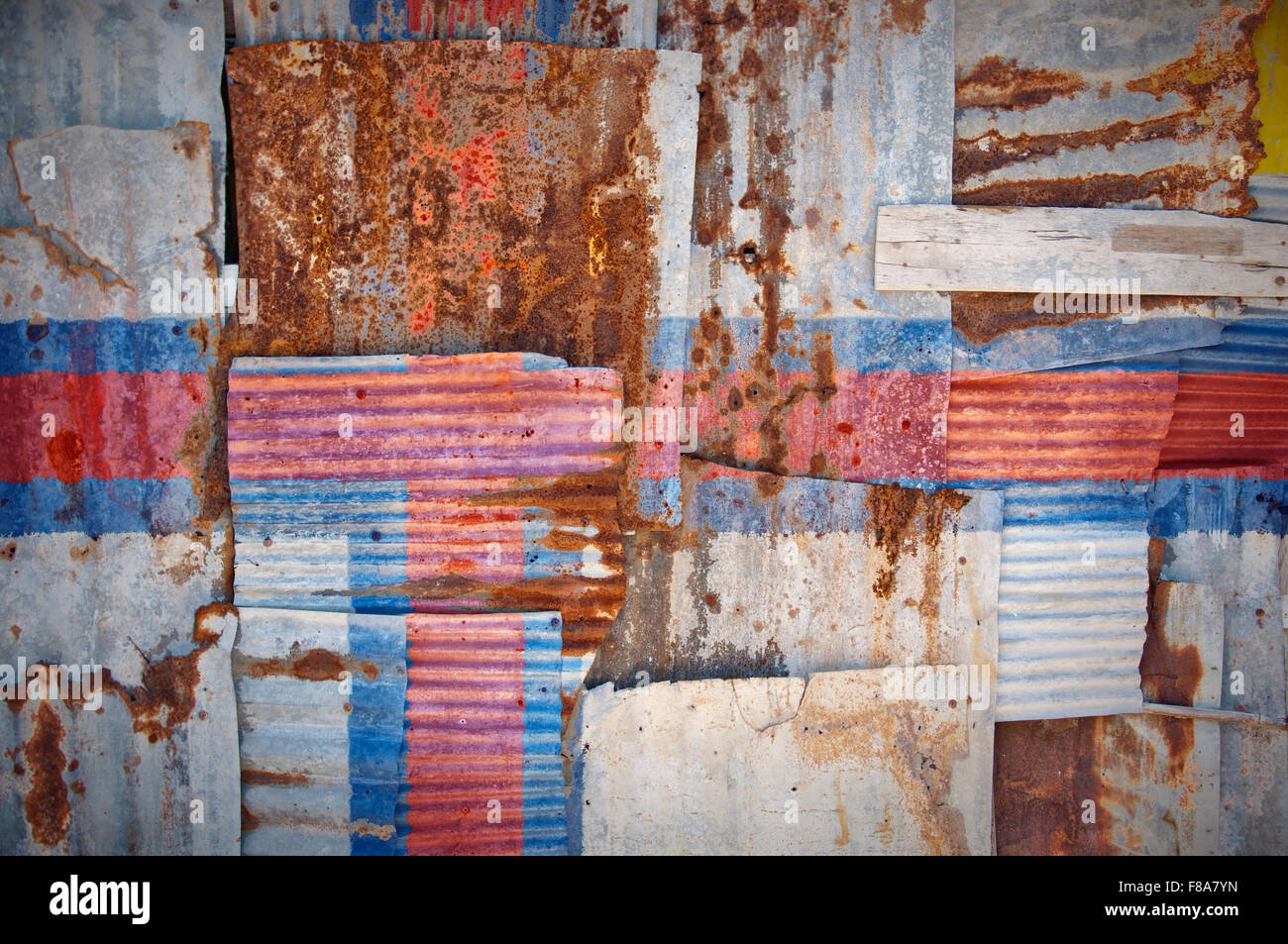 Un abstract immagine di sfondo di bandiera delle isole Faerøer dipinta su di rusty ferro corrugato fogli sovrapposti per formare una parete Foto Stock