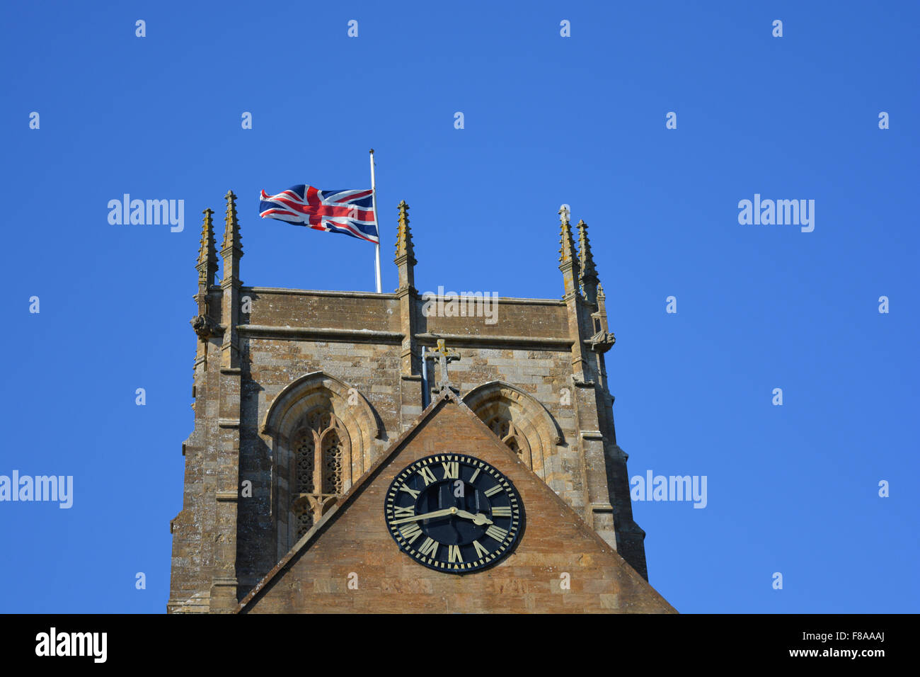 L'Unione Jack battenti a metà il montante sul pennone di Sherborne Abbey, Dorset, Inghilterra Foto Stock