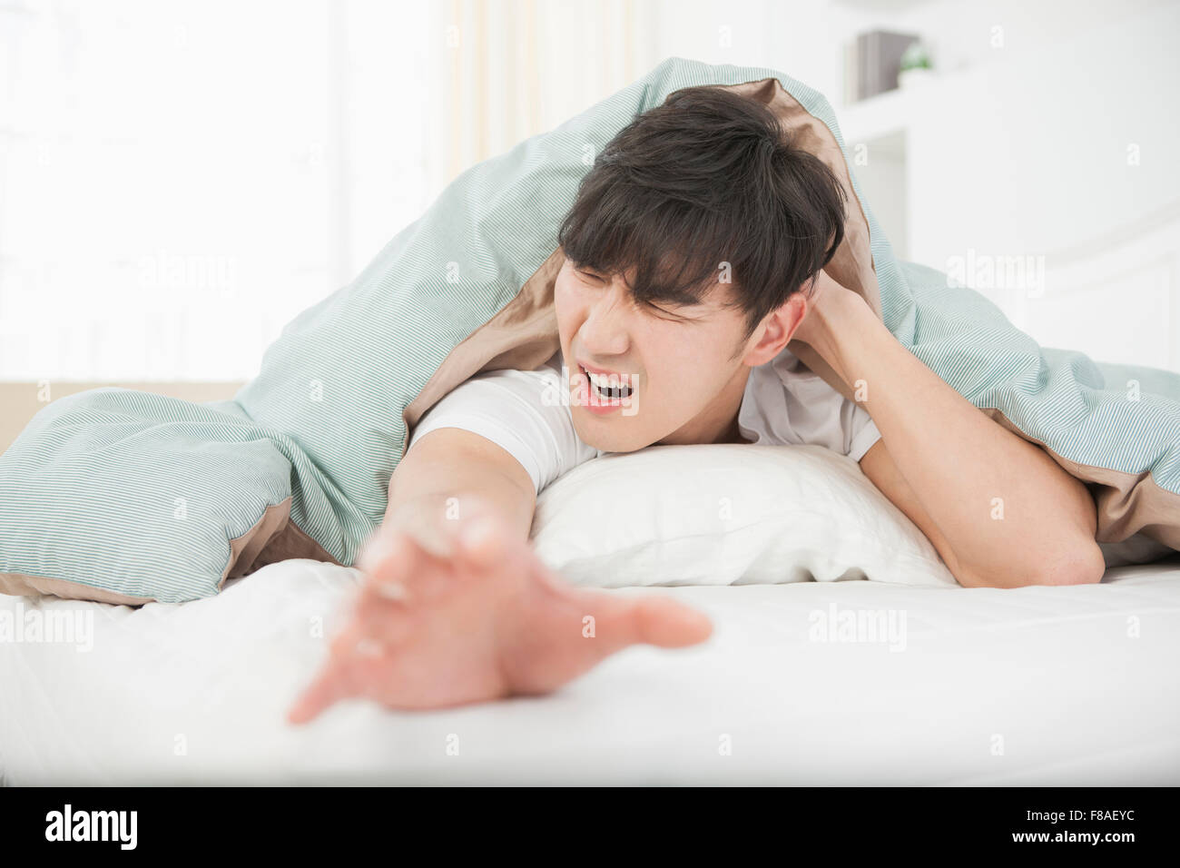 Ha sottolineato l'uomo sdraiato su un lato della faccia e che allunga la mano fuori Foto Stock