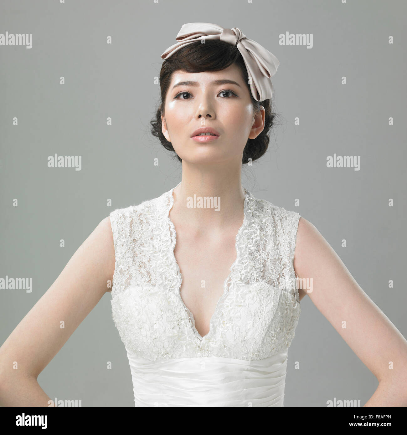 Asian lady in abito bianco con nastro per capelli Foto Stock