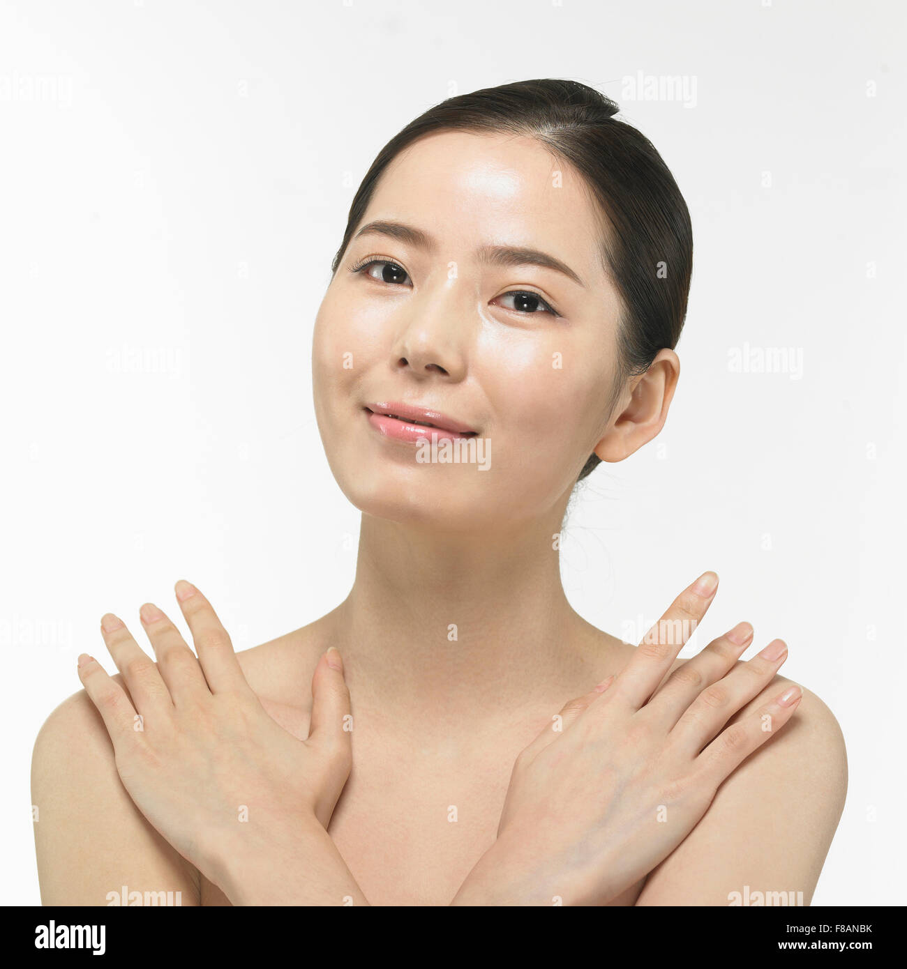 Ritratto di sorridente donna coreana fissando davanti a toccare le spalle Foto Stock