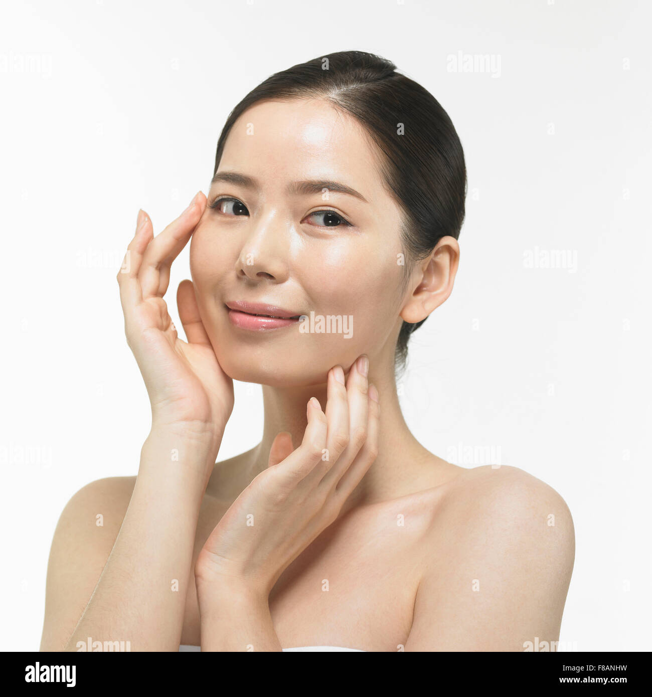 Ritratto di sorridente donna Coreana di toccare il suo volto Foto Stock