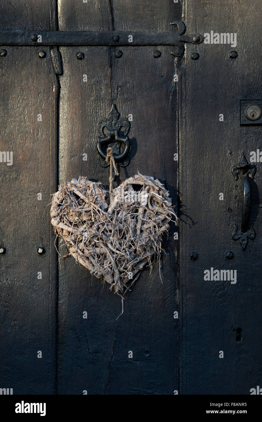 Artigianato cuore di legno su una vecchia quercia porta anteriore Foto Stock