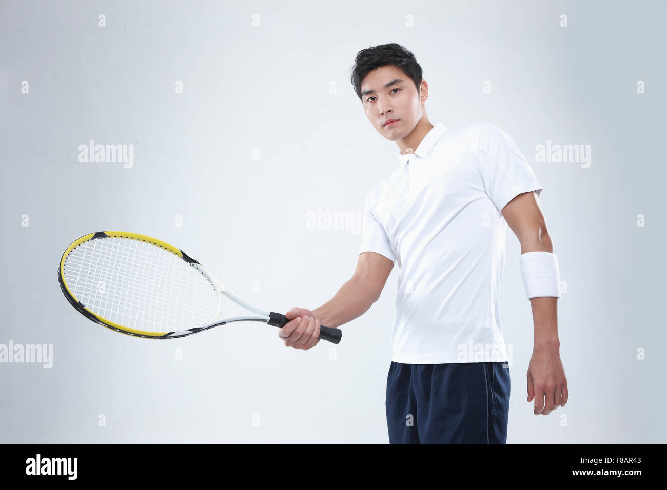 Ritratto di uomo con una racchetta da tennis fissando sulla parte anteriore Foto Stock
