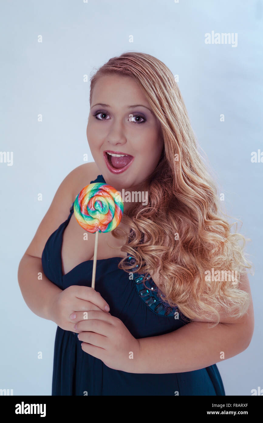 Chubby donna Holding Lollipop con bocca aperta Foto Stock