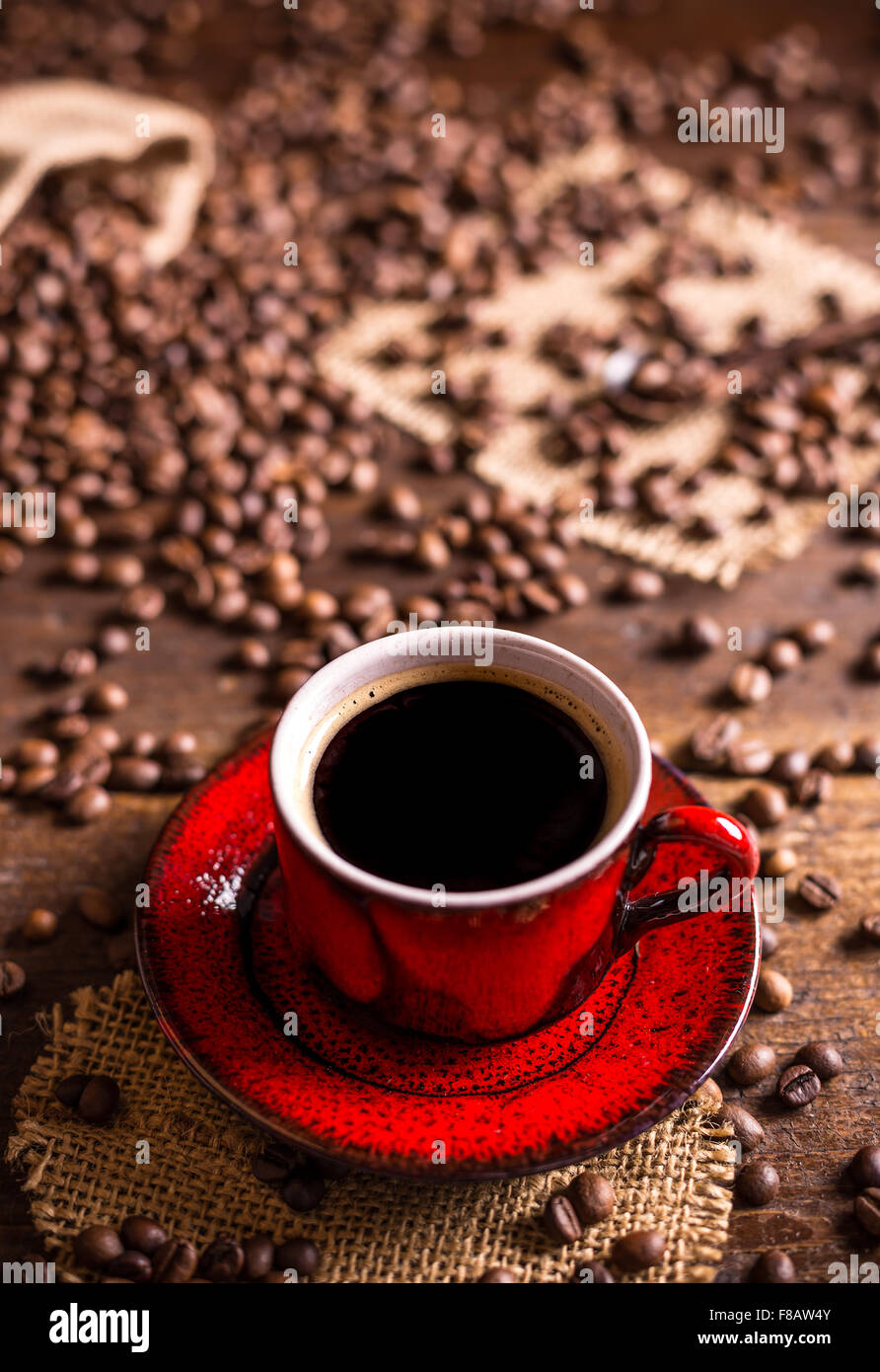 Tazza di caffè nero e i chicchi di caffè su sfondo di legno Foto Stock