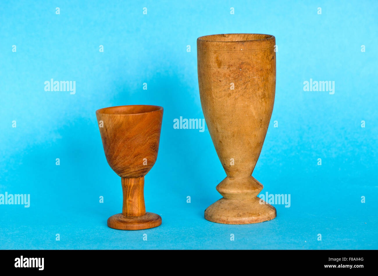 Due antichi in legno fatti a mano bicchieri cup su sfondo blu Foto Stock