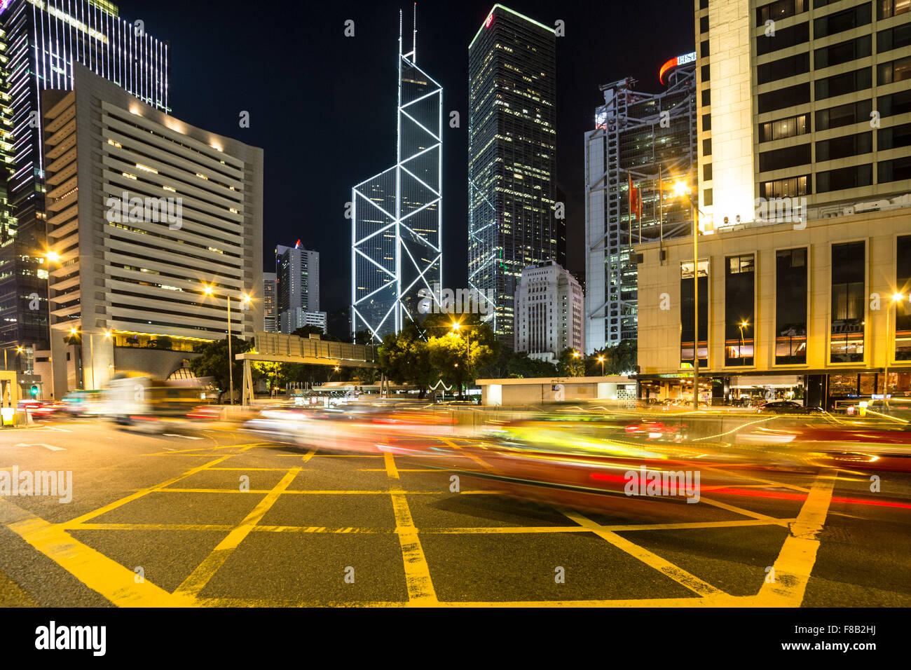 Sfocato moto rush di traffico attraverso il distretto centrale degli affari sull isola di Hong Kong di notte Foto Stock