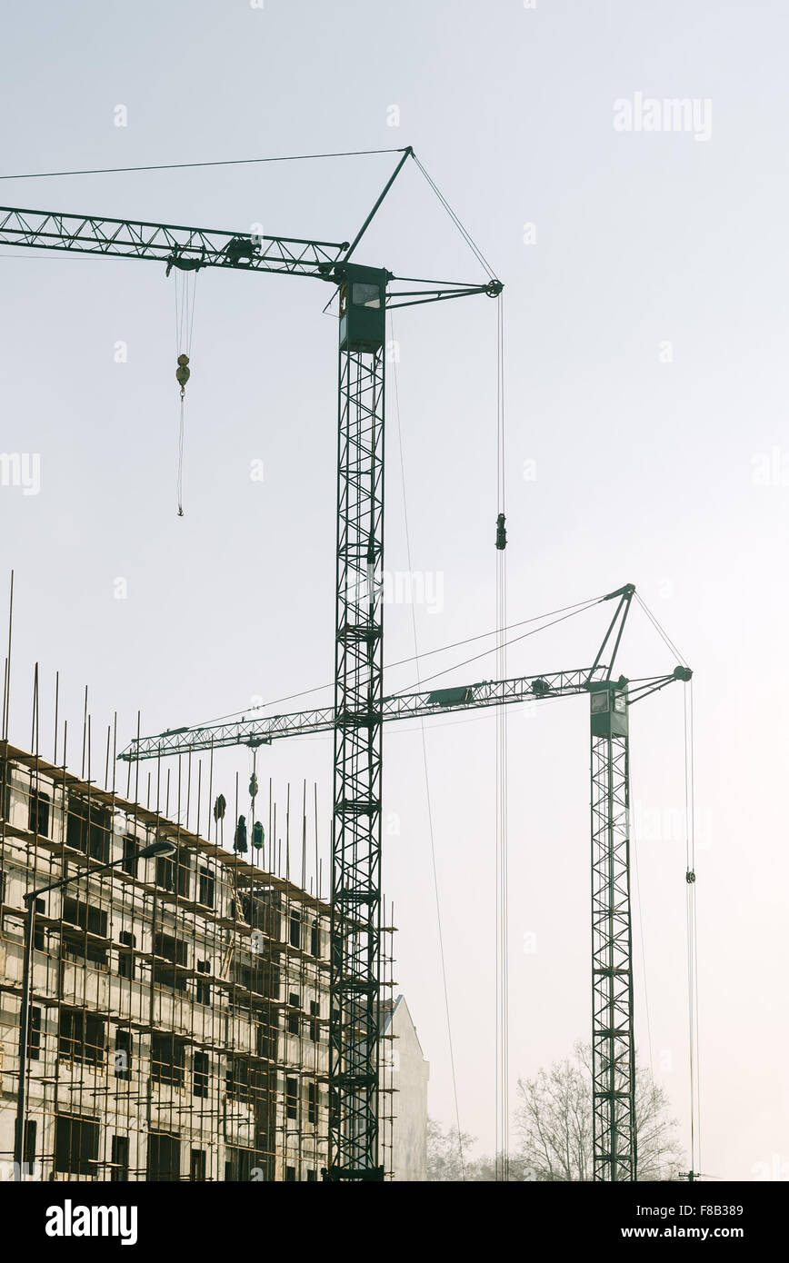 Gru industriali sul sito in costruzione, dai toni rétro immagine Foto Stock