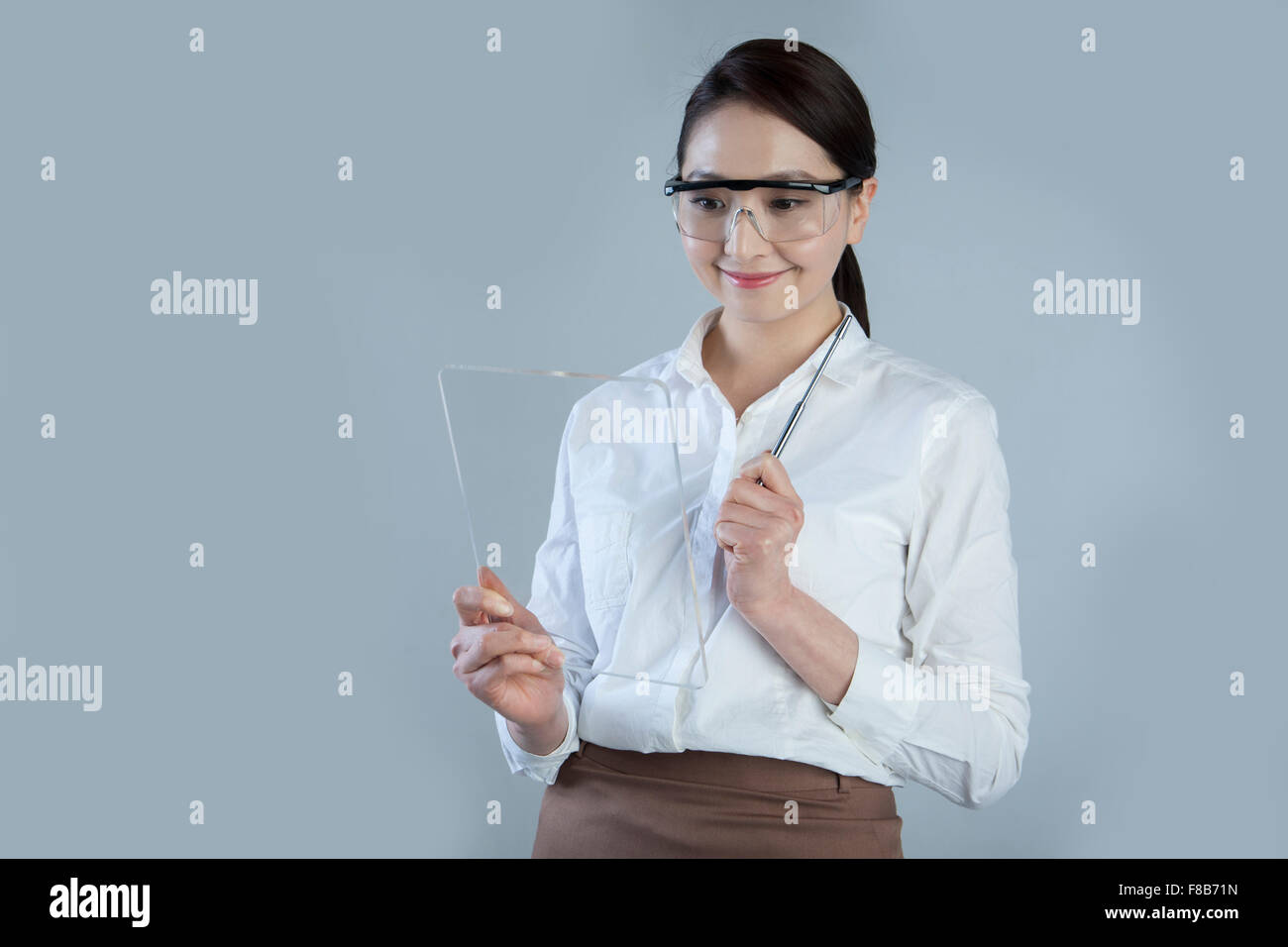 Business donna tenendo premuto il touch screen e indossare gli occhiali di protezione Foto Stock