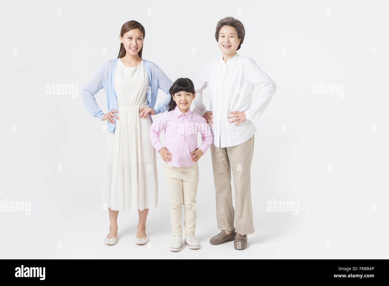 La madre e la figlia e la nipote che rappresentano tre generazioni in piedi insieme con le loro mani su ogni vita Foto Stock