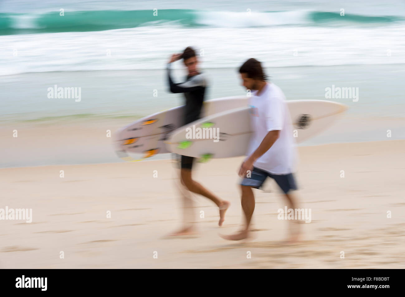 Motion Blur vista astratta di surfers camminando sulla spiaggia di Rio de Janeiro, Brasile Foto Stock