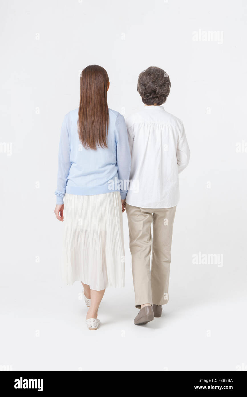Torna aspetto di madre e figlia camminando mano nella mano Foto Stock