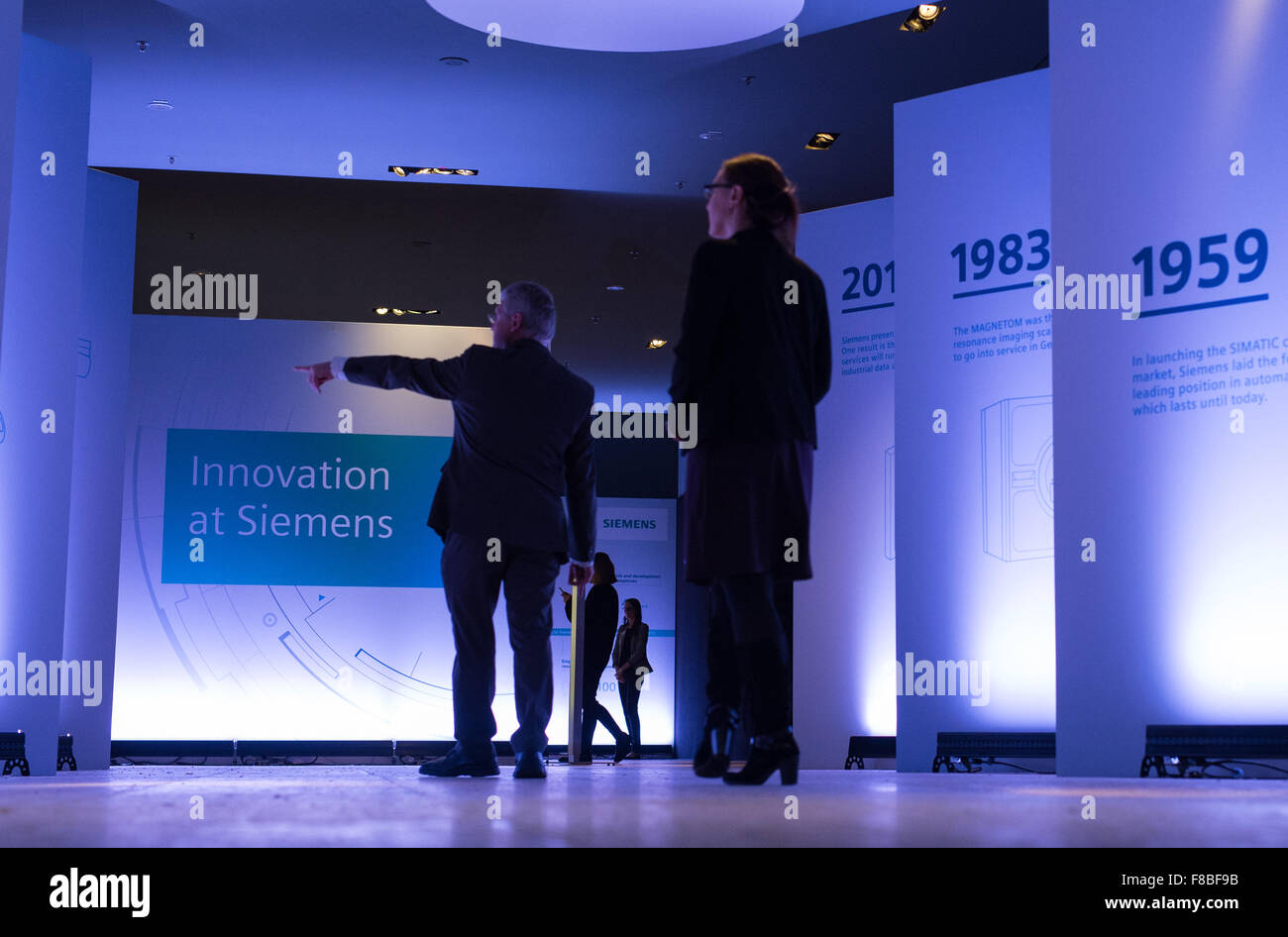 Monaco di Baviera, Germania. L'8 dicembre, 2015. Visitatori sul loro modo ad una Siemens premere conferenza sulla società dell'innovazione strategia, passare lungo un corridoio con una timeline della storia della società e le parole 'Innovazione presso la Siemens' presso il Deutsches Museum di Monaco di Baviera, Germania, 8 dicembre 2015. Siemens prevede di aumentare i propri investimenti in ricerca e sviluppo da parte di trecento milioni di euro per il prossimo esercizio finanziario. Foto: Matthias esitano di fronte/DPA/Alamy Live News Foto Stock
