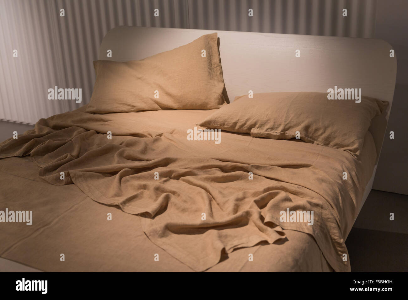 Letto di lusso con fogli sgualciti e una calda coperta Foto Stock