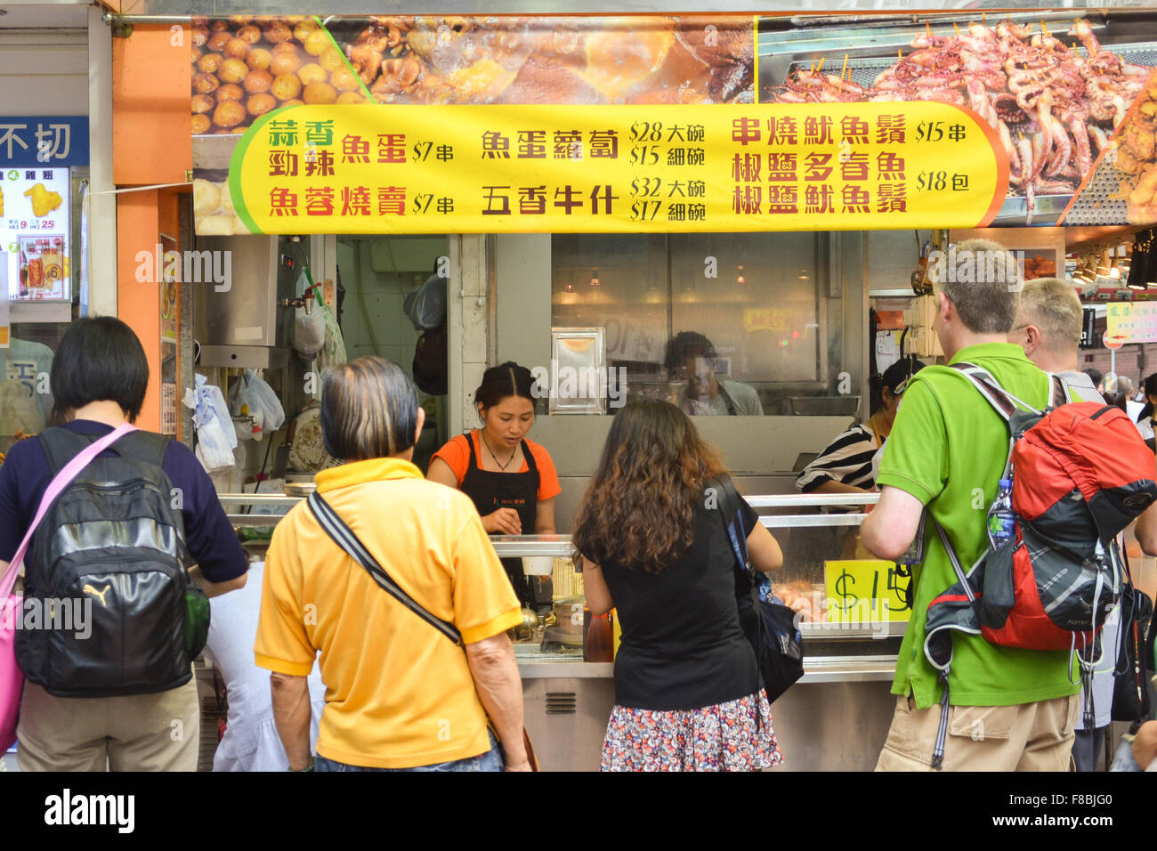 Turisti caucasica il campionamento street food - Hong Kong Foto Stock