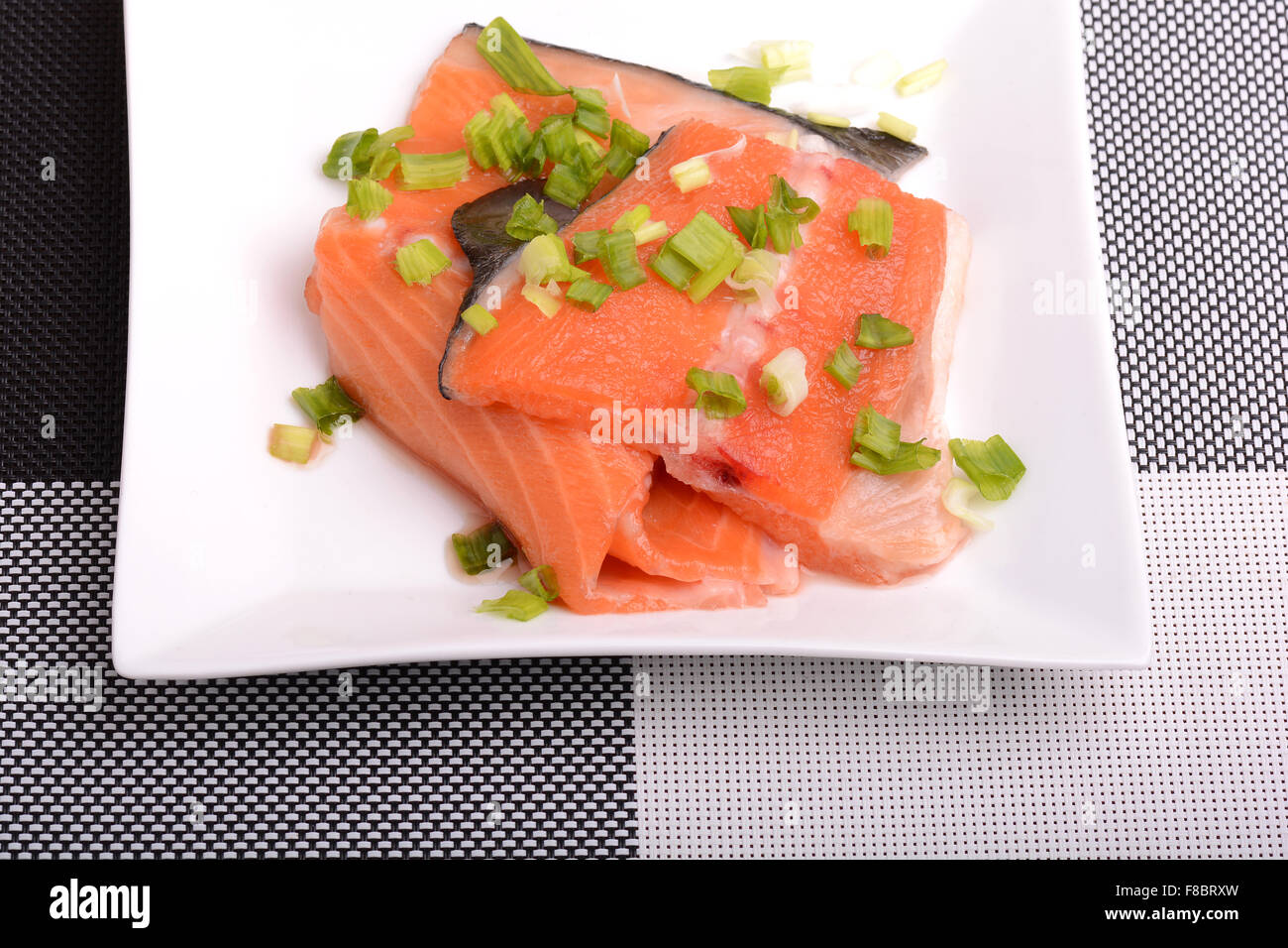 Salate il filetto di salmone con foglie di prezzemolo sulla ciotola bianco Foto Stock