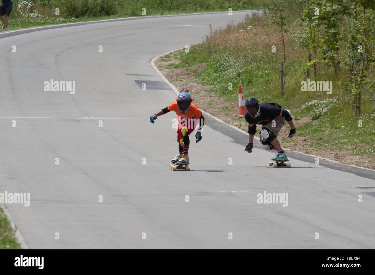 Due down hill skateboarders in nero pieno viso visiere guardare piuttosto misterioso Foto Stock