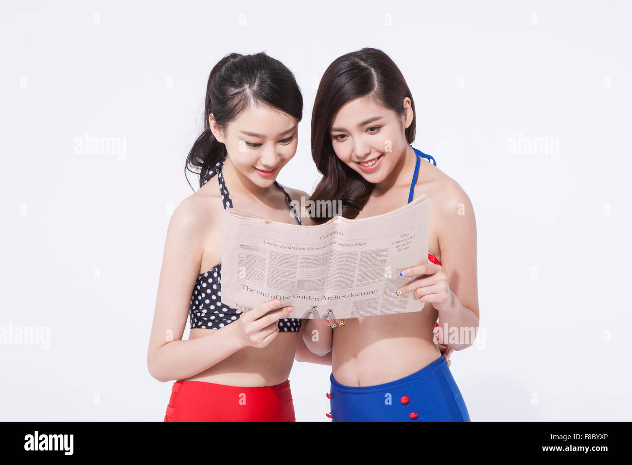 Due donne in stile retrò bikini azienda giornale e guardando insieme Foto Stock