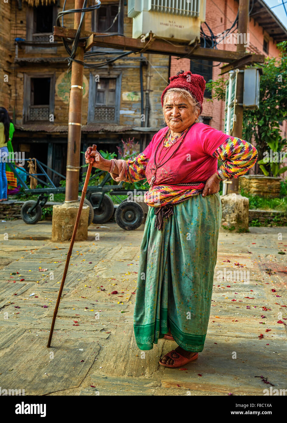 Molto vecchia donna cammina con un bastone da passeggio in strada di Bandipur Foto Stock