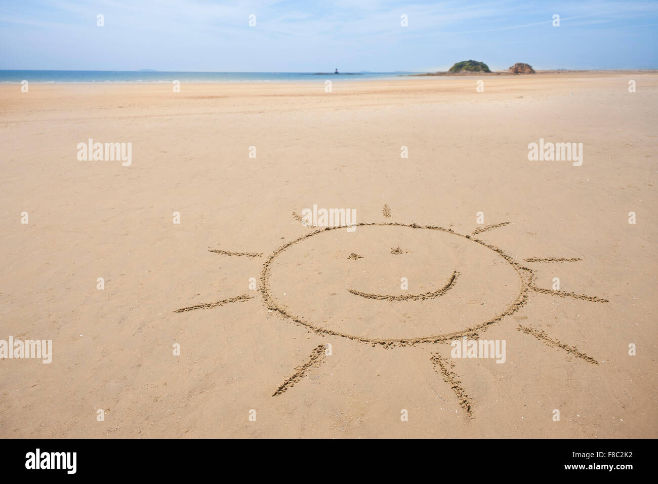 Spazio di copia con sorridente sun disegno sulla sabbia in spiaggia Foto Stock