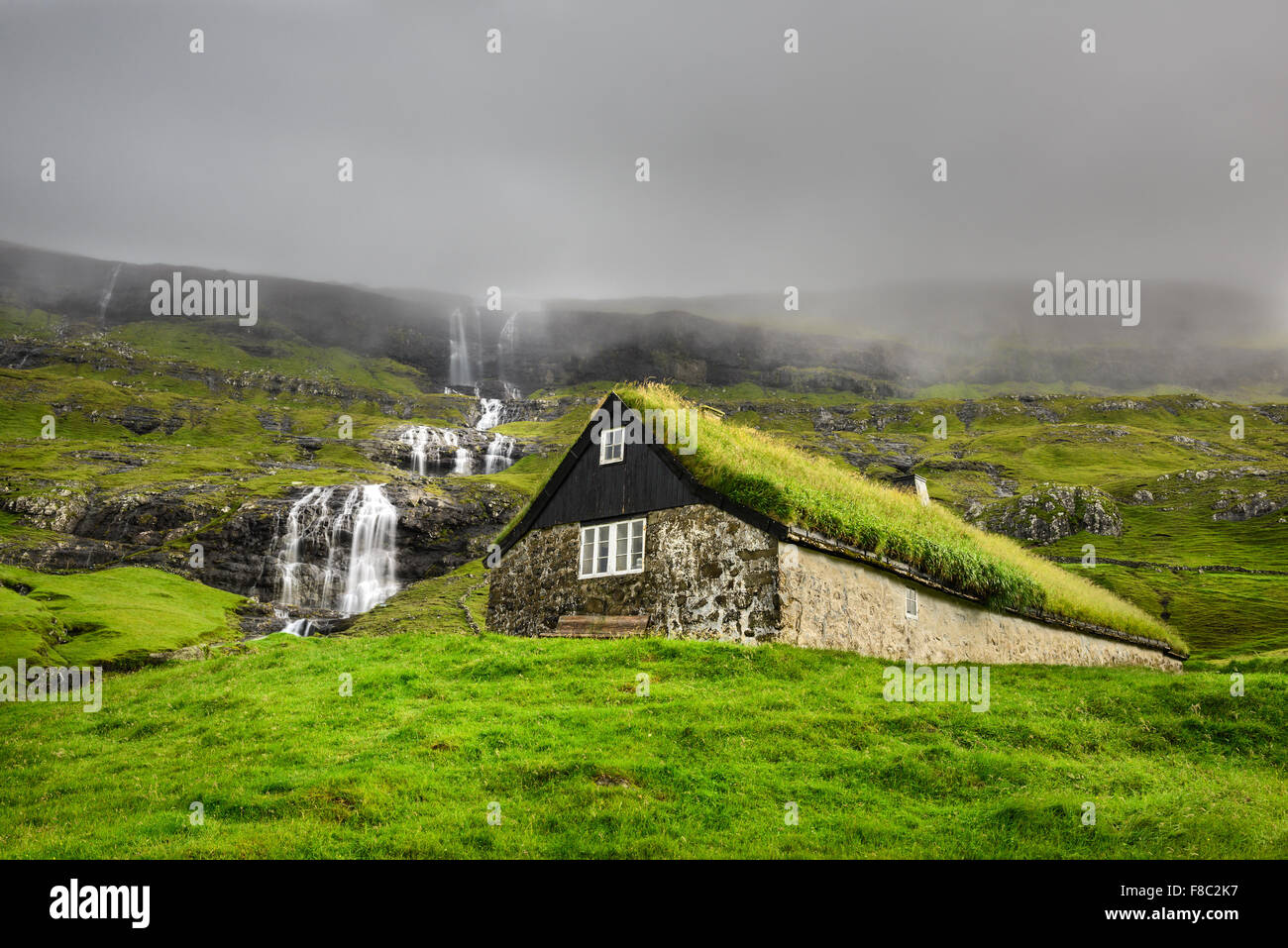 Storica casa in pietra con il tetto del fondo erboso sull isola di Streymoy, Saksun, Isole Faerøer Foto Stock