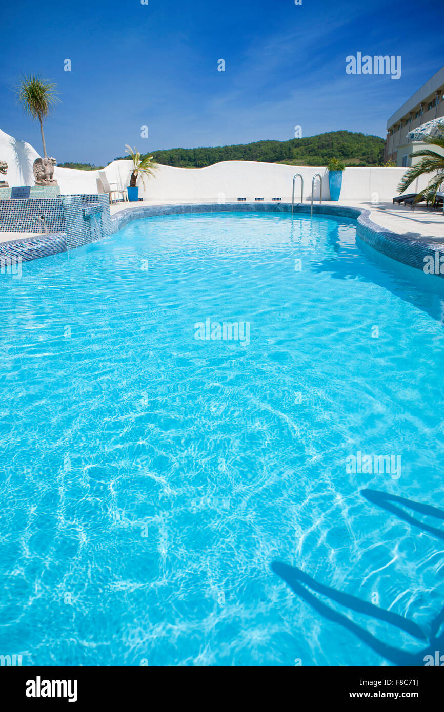 Il colore blu della piscina esterna con Gentle Waves sotto un cielo blu Foto Stock