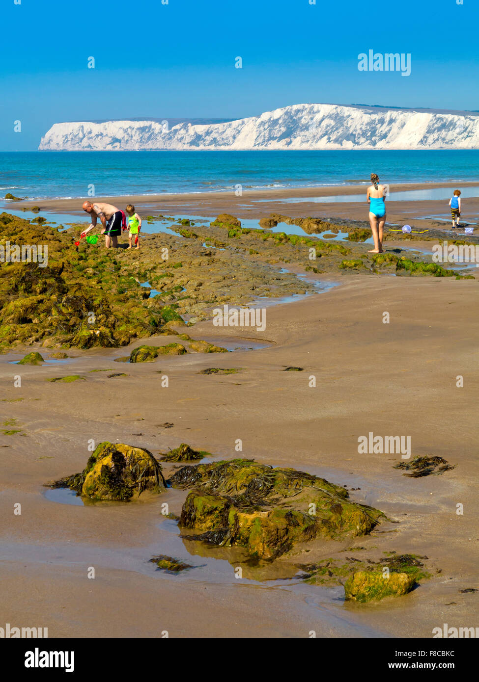 La famiglia sulla spiaggia di Compton Bay sull'Isola di Wight in Inghilterra UK guardando a nord ovest verso chalk scogliere a Tennyson verso il basso Foto Stock