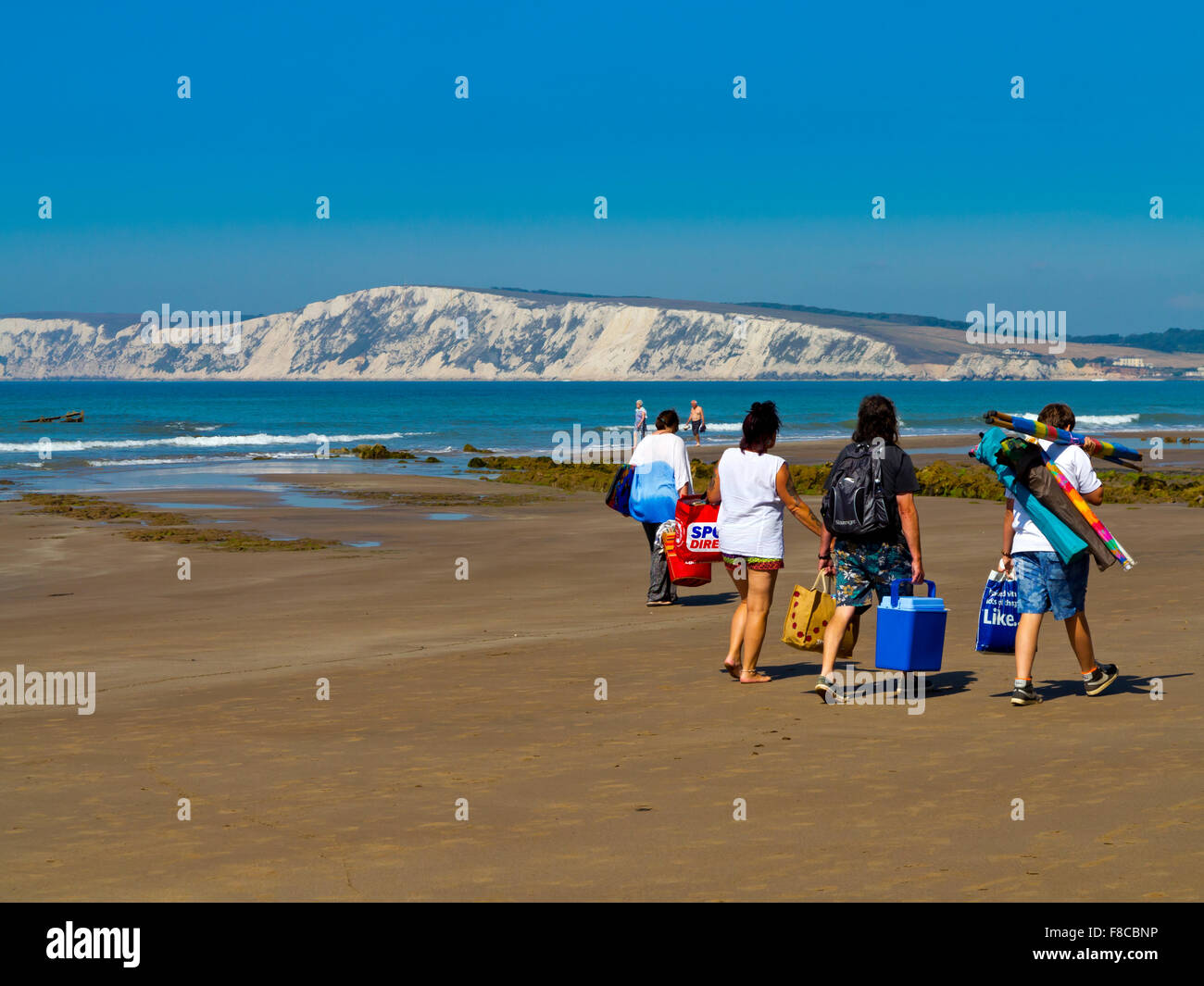 La gente sulla spiaggia di Compton Bay sull'Isola di Wight in Inghilterra UK guardando a nord ovest verso chalk scogliere a Tennyson verso il basso Foto Stock