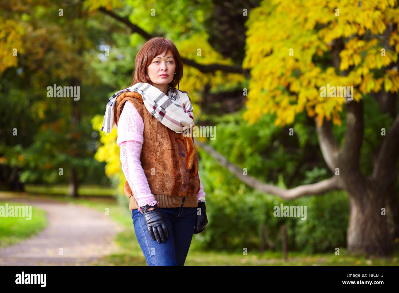 Giovane donna si erge nel parco in autunno Foto Stock