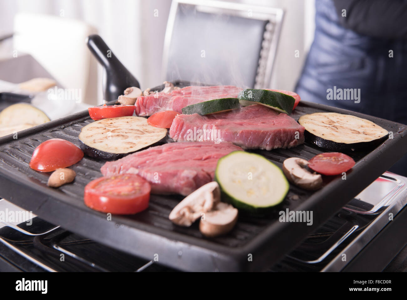 Bistecche e funghi sulla raclette per la cottura Foto Stock