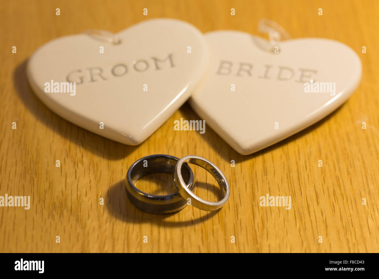 Due cuori con la scritta "sposa' e 'sposo' e due anelli di nozze Foto Stock