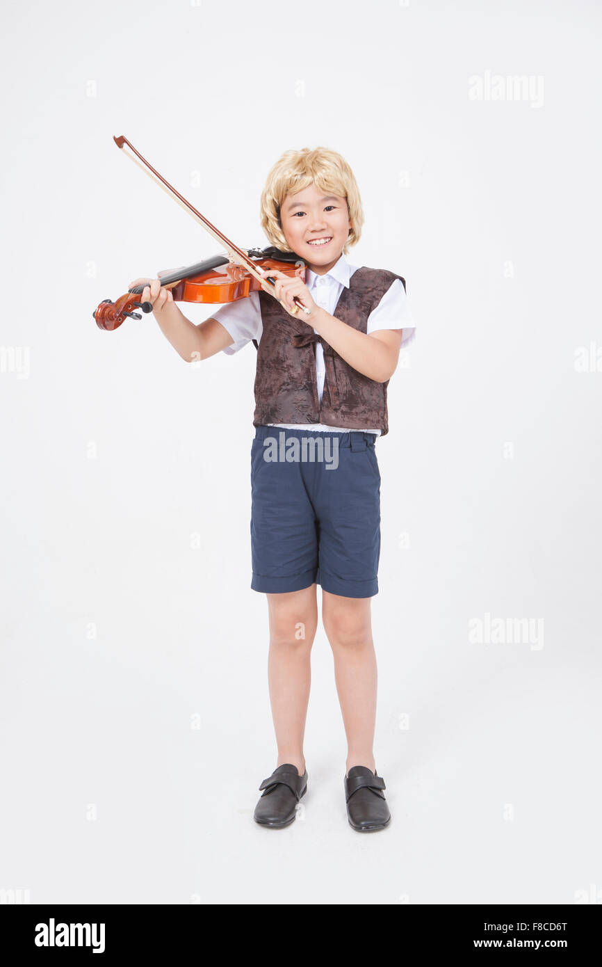 Scuola elementare boy in classico stile musicista in piedi e suona il violino Foto Stock