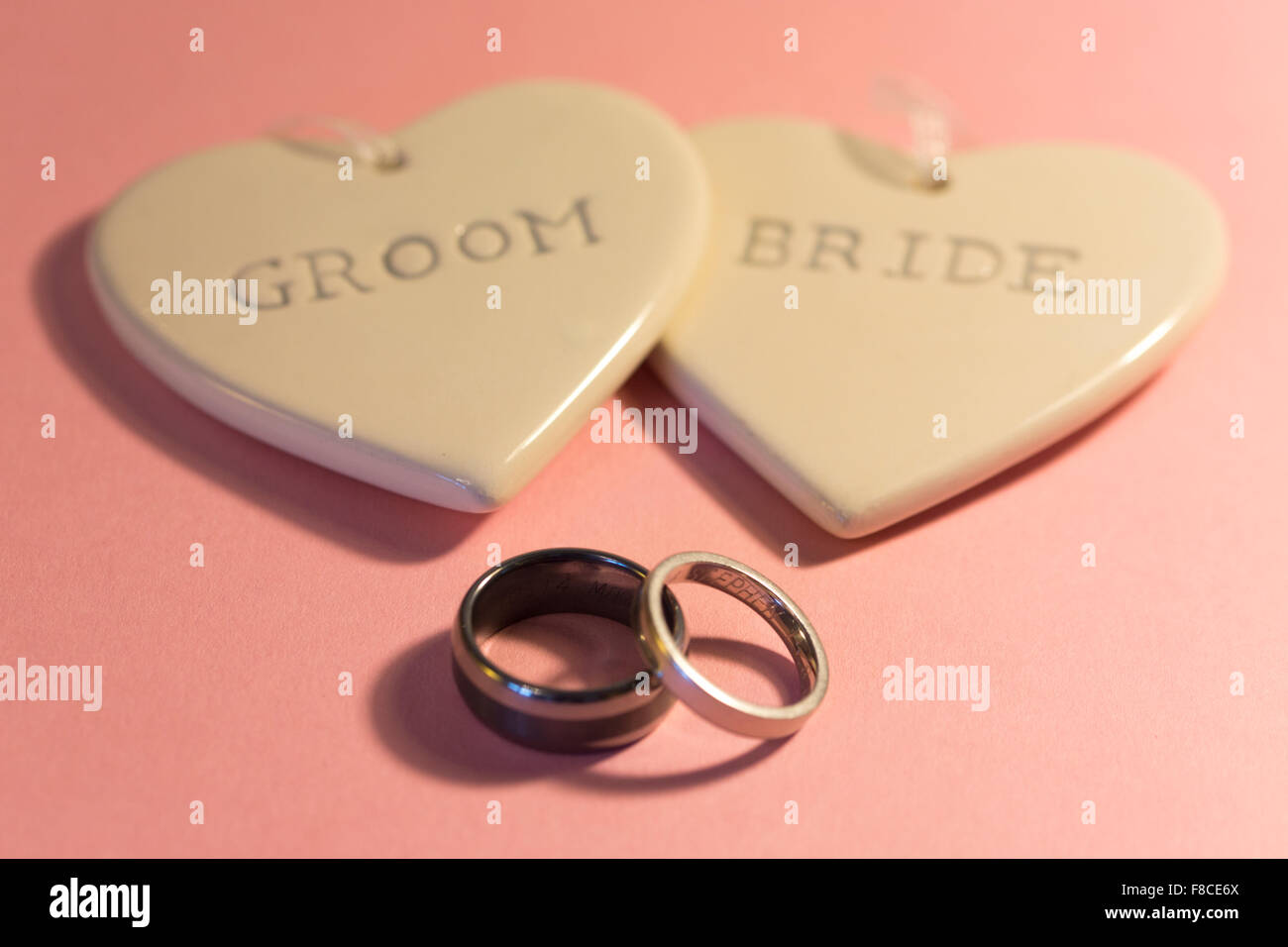 Due cuori con la scritta "sposa' e 'sposo' e due anelli di nozze Foto Stock