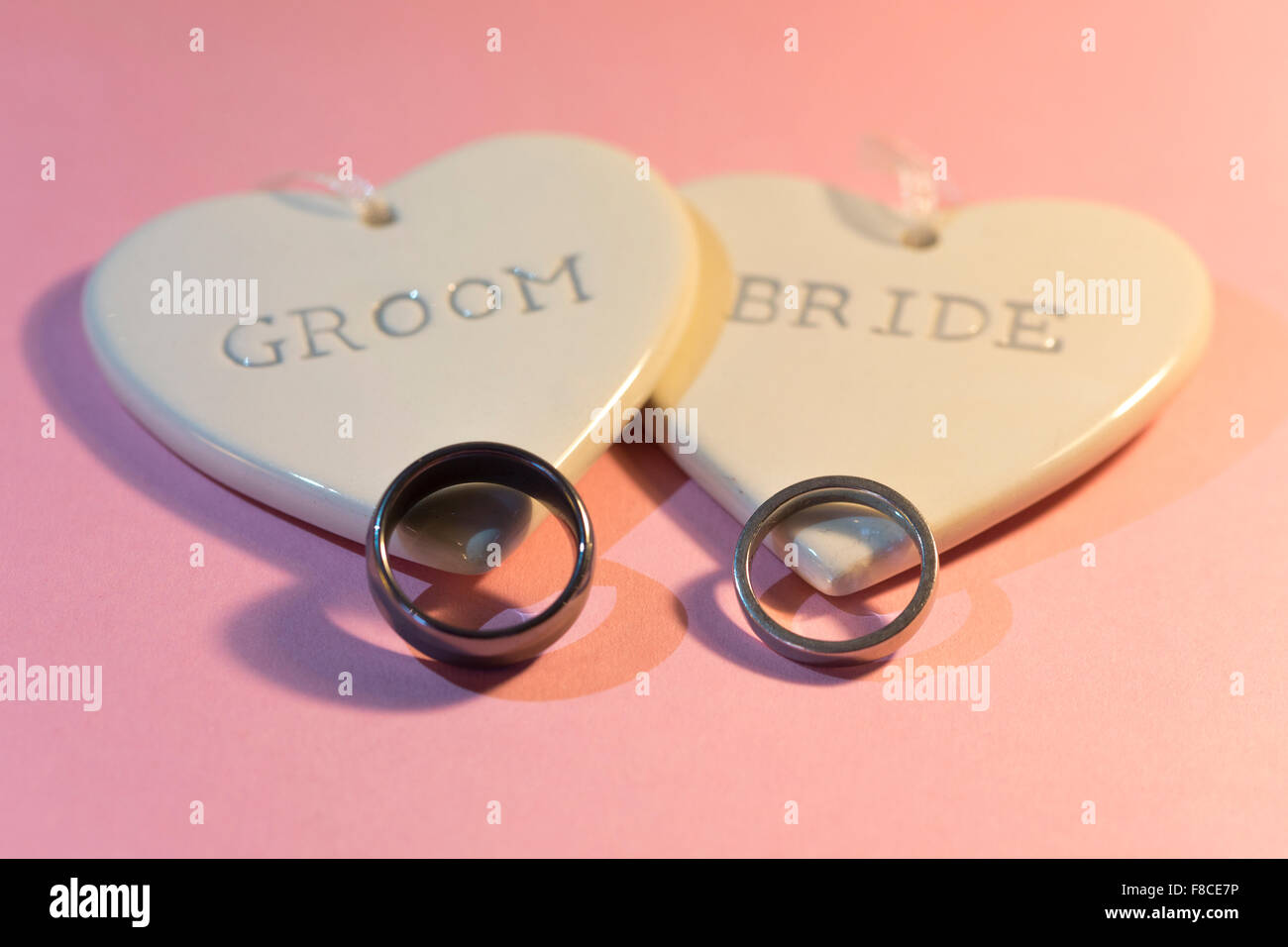 Due cuori con la scritta "sposa' e 'sposo' e due anelli di nozze Foto Stock
