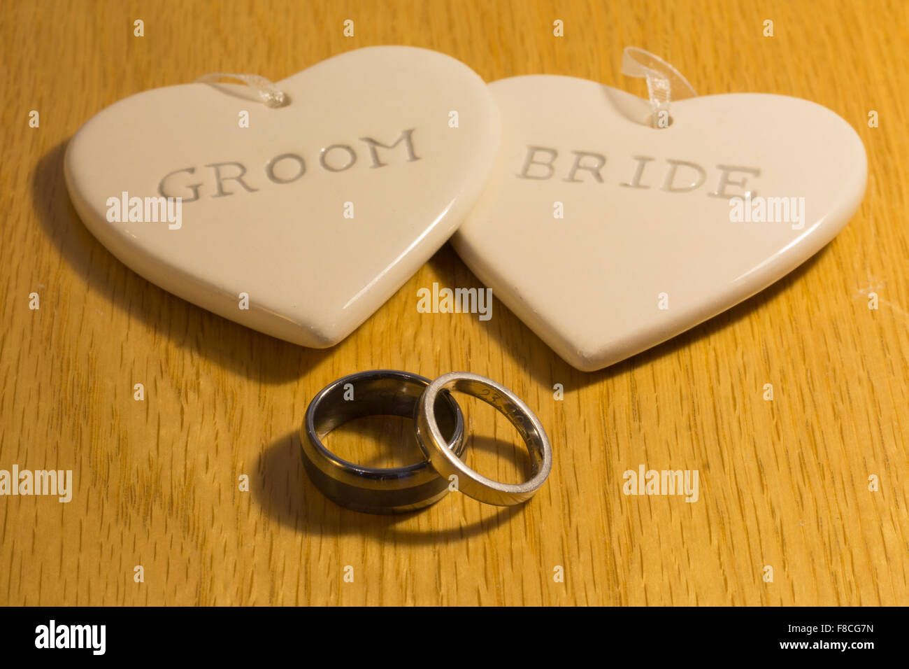 Due cuori con la scritta "sposa' e 'sposo' e due anelli di nozze Foto Stock