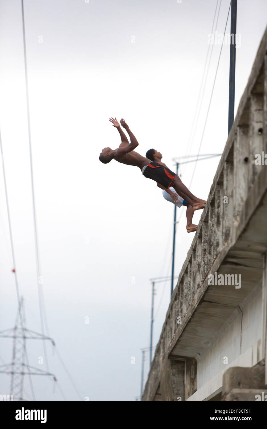 Gli adolescenti jumping lato posteriore da un ponte, Ecuador Foto Stock